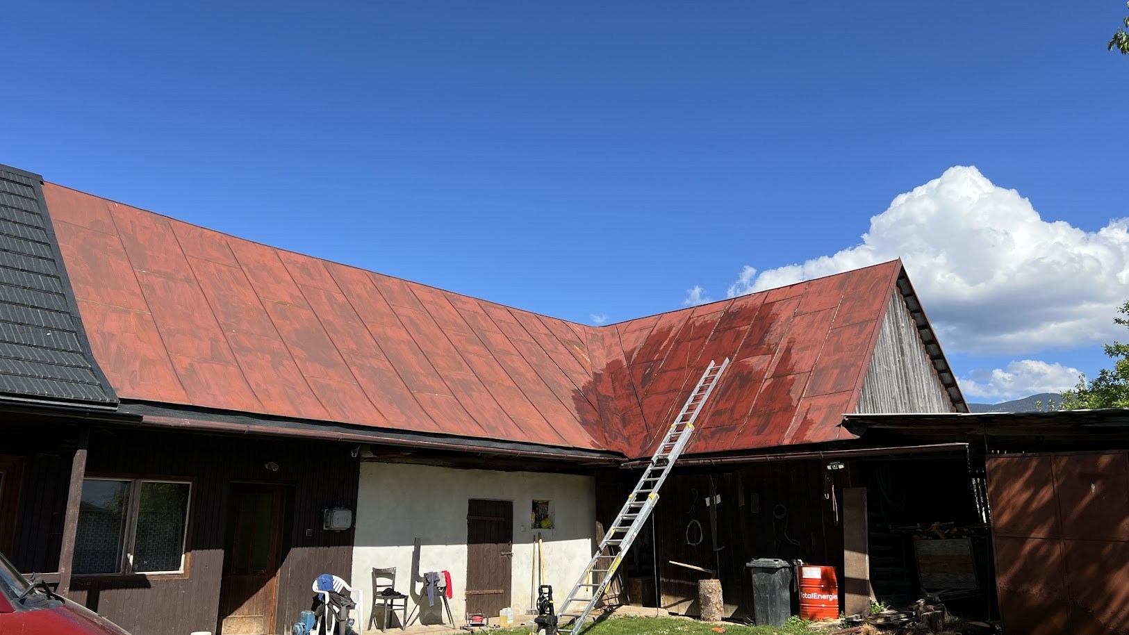 Plechová strecha v Závadke nad Hronom pred náterom — stará farba s opadávajúcou úpravou